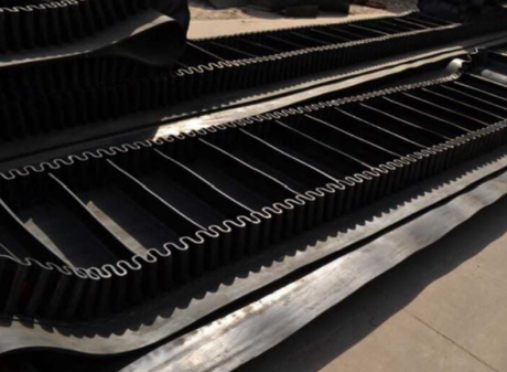 Corrugated sidewall belt with rubber cleats and sidewalls